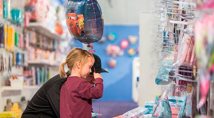 Far og datter med helium ballon kigger på festpynt i Partyland i Slagelse.