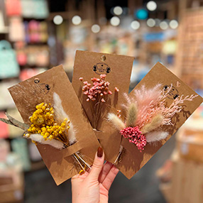 medarbejder der holder tørrede blomster op fra Søstrene Grene