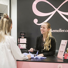 Kunde bliver ekspederet af ekspedient fra Hunkemöller i Slagelse ved kassen.